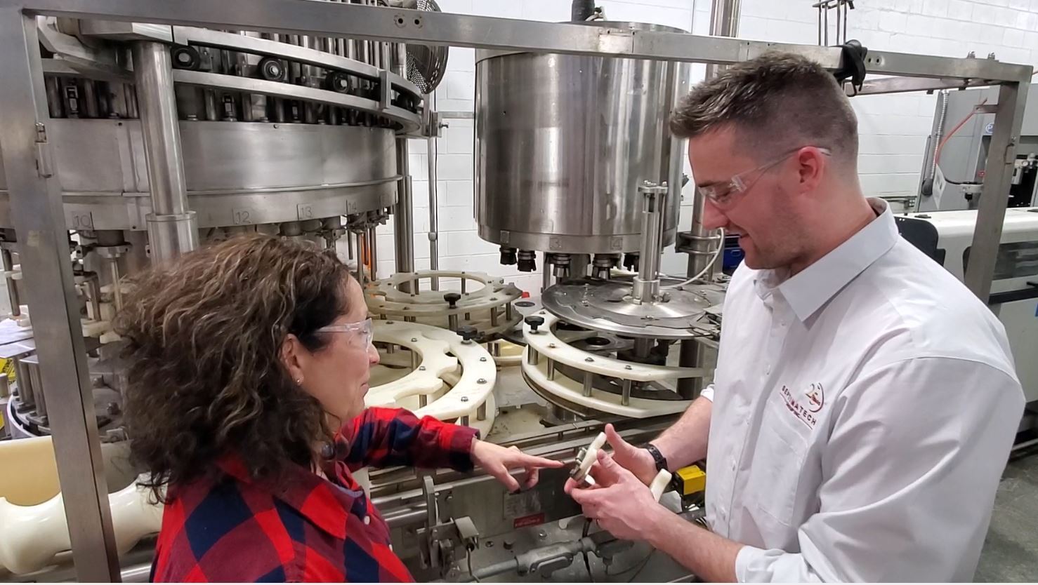 A Septimatech Engineer training an employee on a machine changeover part